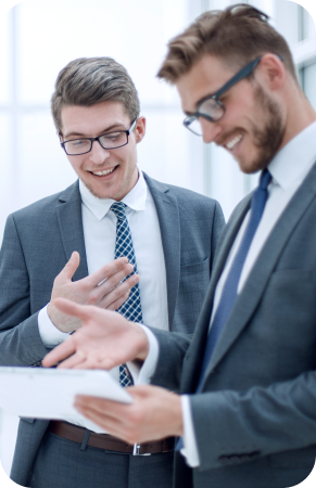 two men in suits looking at a clipboard