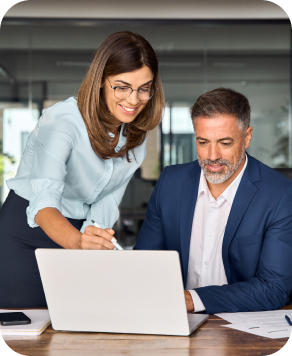 a woman and a man looking at a laptop in a conference room